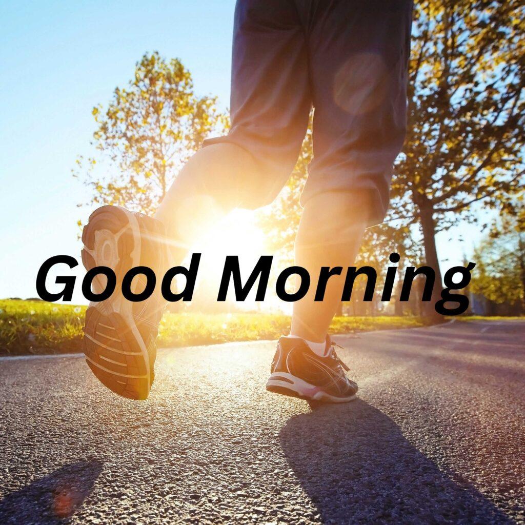 Someone is jogging in the road and in between legs sunlight is falling and it is written Good Morning