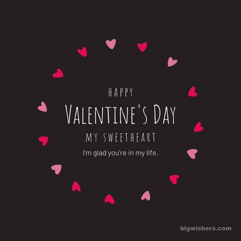 Black background with pink heart with written happy valentines day. with message my Sweetheart my glad you're in my life.